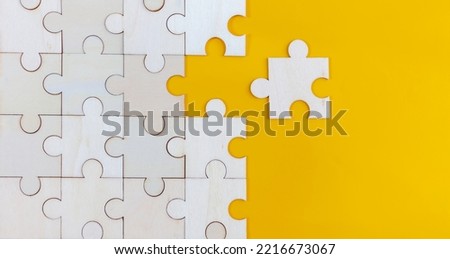 White Wood jigsaw puzzle on yellow background with copy space. Business strategy teamwork or problem solving concept.