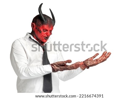 Devilman is standing with an open palm and showing something isolated over white background. Halloween concept