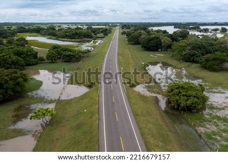 Highway in a rural landscape flooded by proximity to the Magdalena River in the department of Bolivar. Colombia . Royalty-Free Stock Photo #2216679157