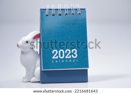 close up of  2023 desk calendar, calendar isolated white  with toy rabbit.