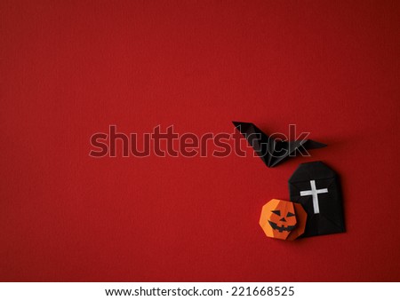Halloween symbols origami bat and pumpkin on a red background