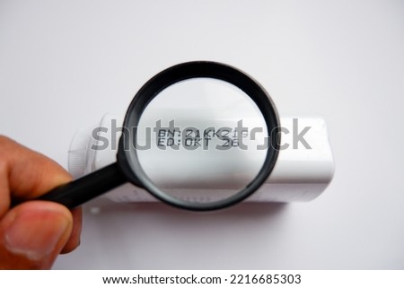 Production code and product expiration viewed from a magnifying glass Royalty-Free Stock Photo #2216685303
