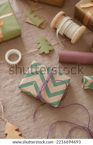 Wrapping a gift box. Flat lay of papers, ribbons, tools for wrapping presents. DIY Christmas decoration.