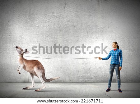 Young woman in casual holding kangaroo on lead