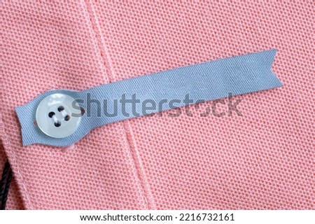 Blank laundry care clothes label on red fabric texture background