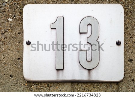 Number 13 on a metal tile, fixed on the wall