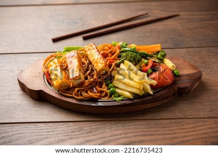 Paneer Sizzler is an Indian version with cottage cheese, salad served sizzling on hot stone dish. Royalty-Free Stock Photo #2216735423