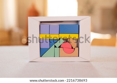 Coloured wooden figures in box on home table. Childrens building blocks. Geometric shapes.  The concept of logical thinking. 