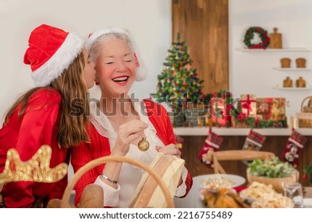Lovely little girl kissing her grandmother as she decorates the Christmas tree 