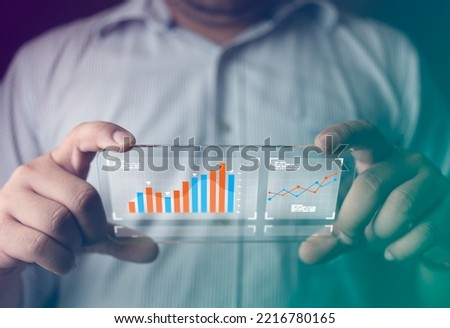 Businessman looking at abstract financial charts on virtual screen in hand. Business information concept, plan graph growth and increase chart positive indicators in his business. Digital marketing.