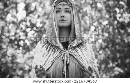 Lady with a long ash blonde hair in Nordic style, elf, Fantasy woman in grey mantle, Scandinavian concept, old world magic. Halloween costume