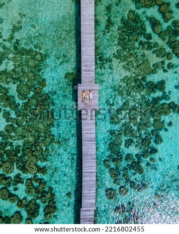 couple man and women on a wooden board walk on a tropical Island in Thailand, Koh Kham near Koh Mak Trat, a wooden pier on a tropical island Royalty-Free Stock Photo #2216802455