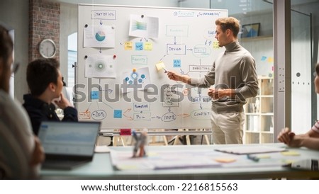 Motivated Group Having a Meeting in the Office Conference Room. Project Manager Explaining Growth Strategy to Diverse Team of Investors Using Whiteboard to Show Charts. Royalty-Free Stock Photo #2216815563