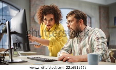 Portrait of Two Creative Colleagues Collaborating and Pointing at the Computer in Modern Office. Biracial Female Manager Consults Male Projects Manager, They Brainstorm on the Project. Royalty-Free Stock Photo #2216815665