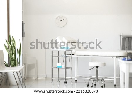 Couch and table with doctor's supplies in modern medical office