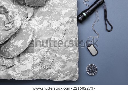 Military uniform, flashlight, tag and compass on grey background