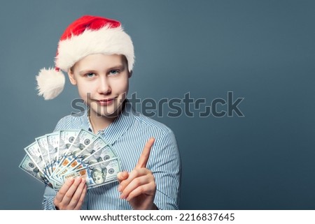 Cute smiling rich teenager girl and money cash us dollars on blue background