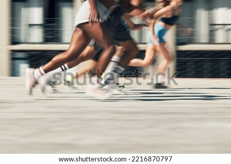 Running, motion and group of people on path together for marathon race, fitness and speed. Fast run team, urban runner club and racing in city street training workout with feet and legs on ground.