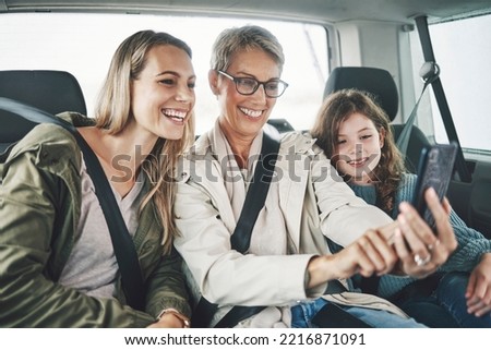 Phone, selfie and happy family in a car for a road trip driving or traveling to a holiday vacation adventure together. Grandma, mother and excited girl or child enjoy pictures for a fun weekend