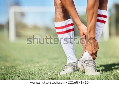 Soccer, sports and ankle pain, injury or accident on a field during a game, exercise or training. Muscle sprain, broken joint or medical emergency of a man athlete at a football pitch during a match. Royalty-Free Stock Photo #2216871715
