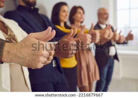 Diverse multiracial team of happy business people giving thumbs up together. Group of multiethnic office workers standing in row and doing like gestures. Close up. Good job, teamwork, success concept
