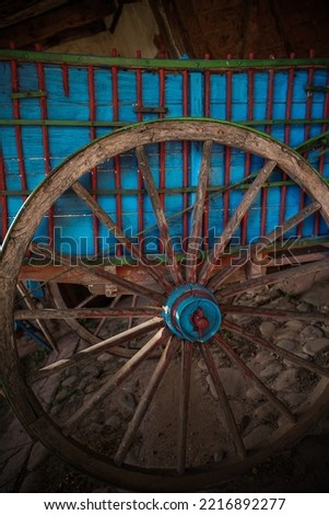 Old cart wheel, in a rustic town in Spain, Vintage style, with old stone and wood background