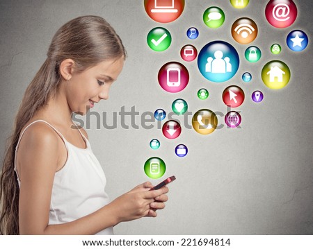 side view profile teenager girl using texting playing on smartphone with social media mobile phone application symbols icons coming flying out of cellphone isolated grey wall background. data plan