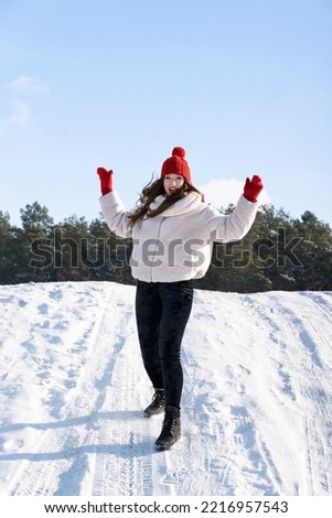 Portrait of young girl in winter outdoors has fun. ertical frame.