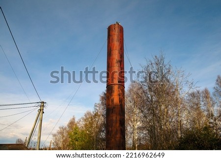 Water tower against the blue sky in spring. Village water supply
