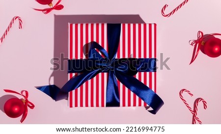 Gift box with blue ribbon on pink background. Flat lay, top view. High quality photo