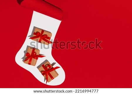 Christmas sock with gifts on white and red background. Space for text. Mockup. High quality photo