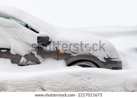 stuck car in snowdrift, passenger car is covered with snow in winter, winter road collapse Royalty-Free Stock Photo #2217015673