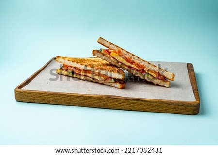 sandwich with salmon and scrambled eggs on a wooden board on a c