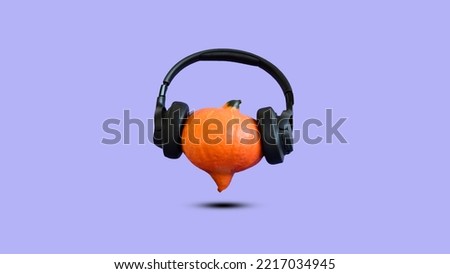 Creative Halloween design made of pumpkin with headphones against pastel lilac background. Minimal concept. Copy space. Autumn art. Pastel fall. Halloween party.