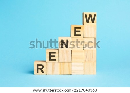 on pyramid with wooden cubes text renew, blue background