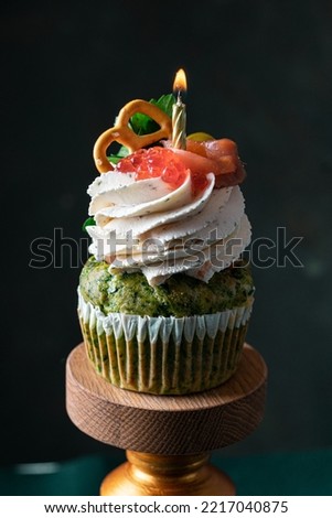 tasty birthday salted cupcake with candle on dark background . Vertical
