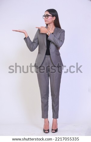 Business woman presenting a copyspace with her hand and pointing towards it too. Isolated on white background.