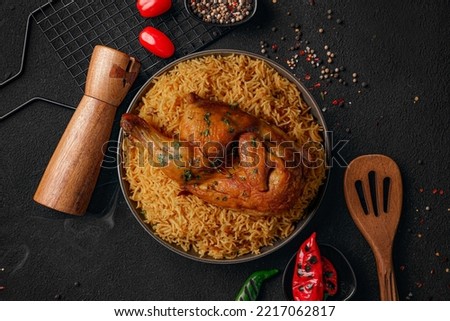The national Saudi Arabian dish chicken kabsa with roasted chicken quarter and almonds Royalty-Free Stock Photo #2217062817