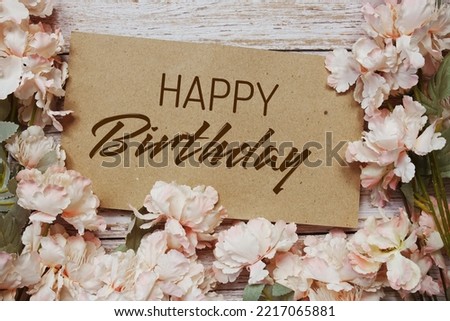 Happy Birthday typography text with flowers frame on wooden background