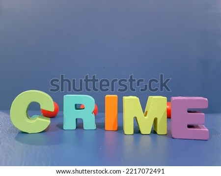 CRIME words, various colored alphabets from wooden toys with blue isolated background 
