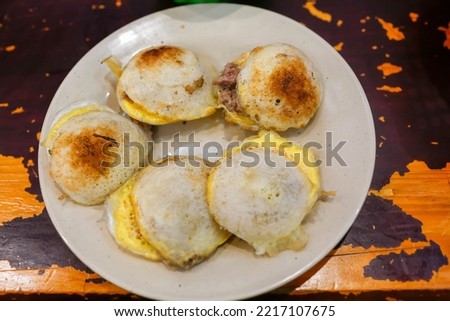 Banh Can is a type of savoury mini pancake which is very popular in Da Lat. The mini pancakes are normally served in a dish of ten to 12 pieces Royalty-Free Stock Photo #2217107675