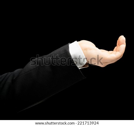Caucasian male hand in a business suit, showing the asking for help gesture sign, low-key lighting composition, isolated over the black background
