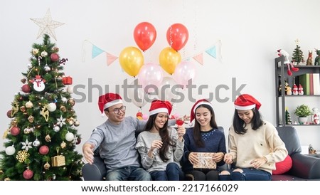 young asian man and woman celebrate Christmas eve in room decorated with Christmas tree