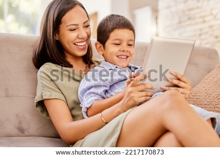 Family, digital tablet and mother and son relax on sofa, bond and laugh at online game, movie or cartoon. Happy family, child and parent watching, smiling and enjoy internet streaming in living room