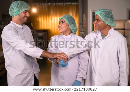 Three inspector scientists corporate checking stock juice in glass bottle food product at food industry	