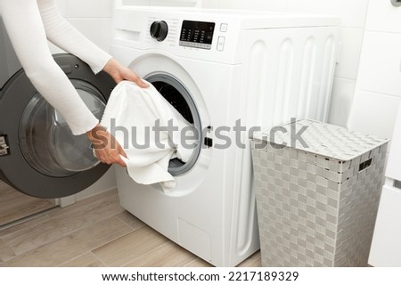 General shot of a washing machine loaded with clothes Royalty-Free Stock Photo #2217189329