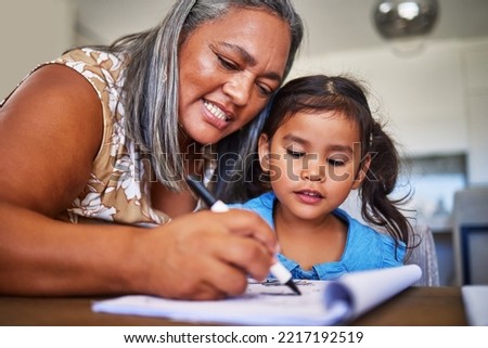 Girl homework, learning and grandmother helping child with school education in a notebook in their home. Kid and senior woman, creative drawing or homework writing for knowledge and learning alphabet