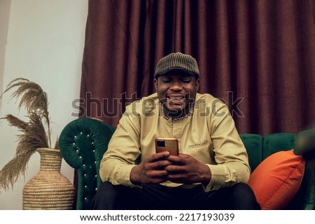 A young excited African man operating his phone Royalty-Free Stock Photo #2217193039