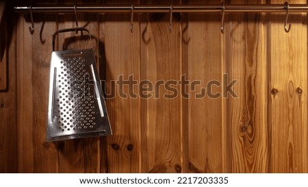The grater hangs in the kitchen. Wooden kitchen