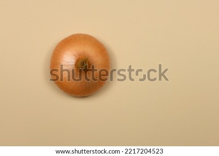 Yellow onion bulbs  on beige background. High resolution photo. Full depth of field.